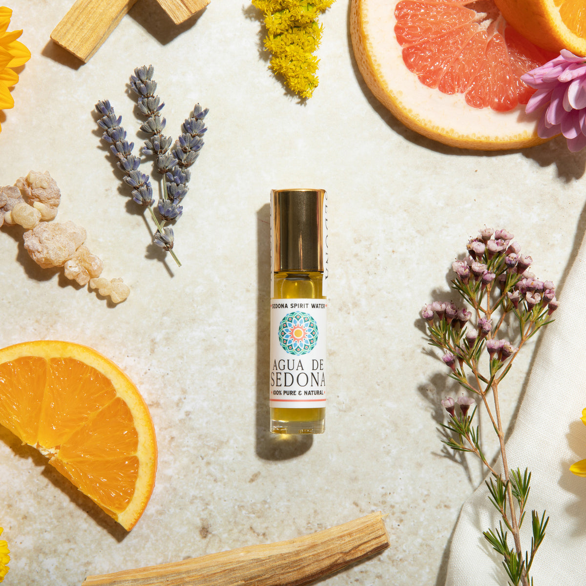 Agua de Sedona roll-on perfume with citrus, lavender, florals, and herbs on stone background