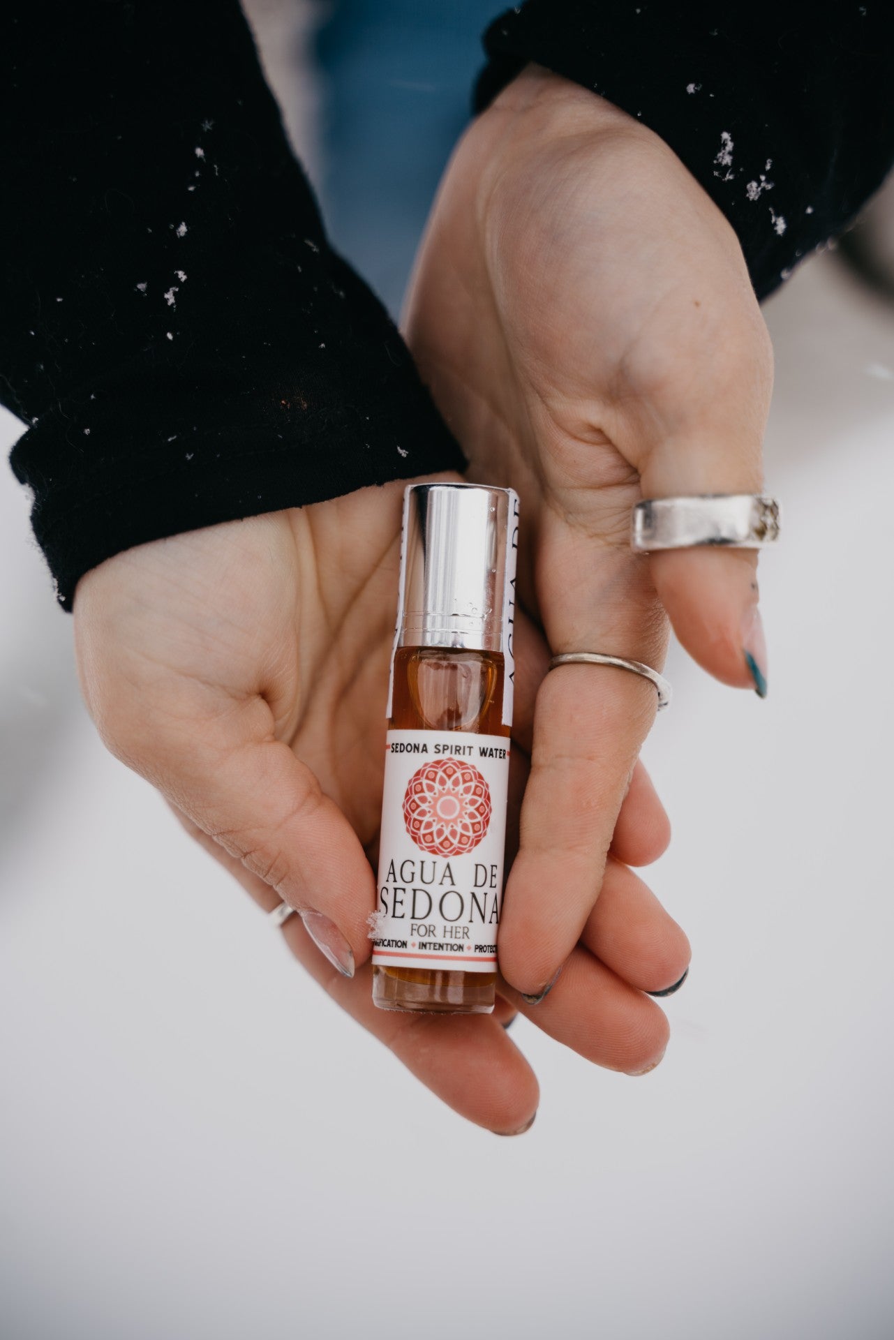 Woman holding the Sedona Spirit Water “For Her” edition in a clear glass bottle. 